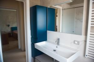 a bathroom with a white sink and a blue cabinet at Casa di Olly in Sona +33 photos