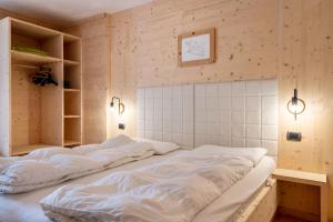two beds in a room with wooden walls at Apartment Sassolungo in Campitello di Fassa