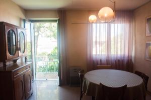 a dining room with a table and a large window at Casa di Olly in Sona
