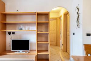 a room with a desk with a computer on a shelf at Apartment Sassolungo in Campitello di Fassa