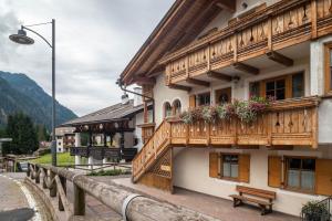 a building with wooden balconies and a bench in front at Apartment Sassolungo in Campitello di Fassa