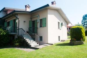 a white house with green shutters and stairs at Casa di Olly in Sona