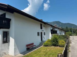 a white building with a bench on the side of it at Haus Rübezahl in Bayerisch Gmain