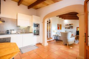 a kitchen with white cabinets and a dining room at Finca Rural Es Pujol in Sóller