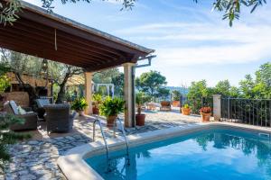 a swimming pool with a pergola next to a house at Finca Rural Es Pujol in Sóller