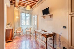 a living room with a table and a tv on the wall at Romantic Apartment Near Pisa Lucca in Bientina