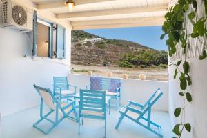 a group of chairs and tables on a balcony at Beachfront Lampis Dolphin 1 in Skala