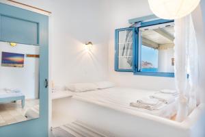 a white room with a bed and a mirror at Beachfront Lampis Dolphin 1 in Skala