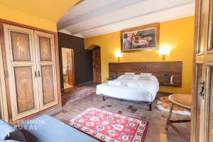a bedroom with a large white bed and yellow walls at Can Vilallonga in Sant Feliu de Pallerols +37 photos