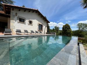 a swimming pool in front of a house at Can Vilallonga in Sant Feliu de Pallerols