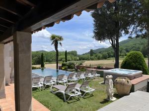 a patio with chairs and a swimming pool at Can Vilallonga in Sant Feliu de Pallerols