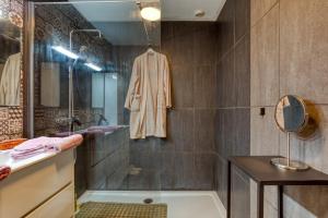 a bathroom with a shower and a robe on the wall at Chambre d’hôtes Béziers in Béziers +16 photos