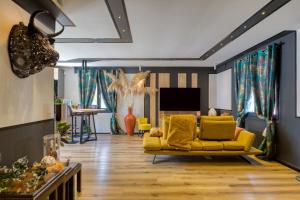 a living room with a yellow couch and a television at Chambre d’hôtes Béziers in Béziers