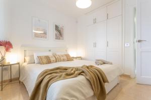 a white bedroom with a bed with a blanket on it at Oasis Duna - Casa Amanay in Corralejo +25 photos