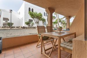 a table and chairs on a patio with a view of a street at Oasis Duna - Casa Amanay in Corralejo