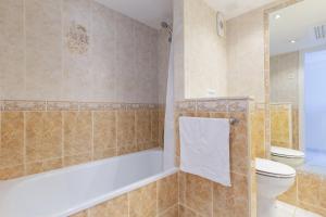 a bathroom with a tub and a toilet and a shower at Marina view apartment in Fuengirola