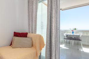a room with a chair and a table and a window at Marina view apartment in Fuengirola +14 photos