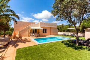 a house with a swimming pool and a yard at Casa Antonio in Cala Llombards