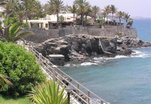 a staircase leading to a beach with palm trees and houses at Nueva Baviera 42 in San Bartolomé