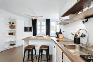 a kitchen with a sink and a counter with stools at La Terrasse, Rivedoux Beach House in Rivedoux-Plage