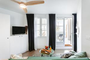 a living room with a green couch and a tv at La Terrasse, Rivedoux Beach House in Rivedoux-Plage +13 photos