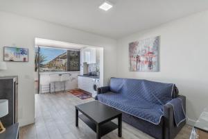a living room with a blue couch and a kitchen at Daniel House in Mogán