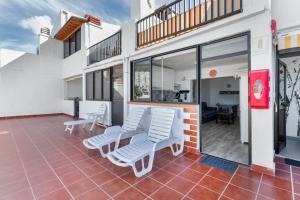 a patio with two white chairs and a building at Daniel House in Mogán