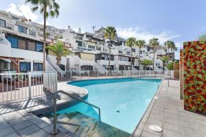 a swimming pool in front of some apartment buildings at Daniel House in Mogán