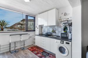 a kitchen with a washing machine and a window at Daniel House in Mogán