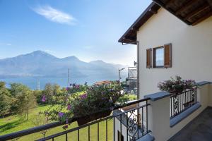 a balcony with flowers and a view of the water at Casa Giuly in Stazzona
