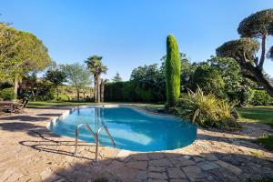 a small swimming pool in a yard with trees at Casa Romaní in El Bruc