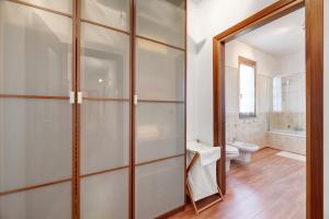 a bathroom with a toilet and a glass shower door at Casa Giuly in Stazzona +23 photos