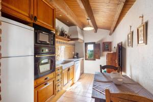 a kitchen with a refrigerator and a table in it at Casa Romaní in El Bruc