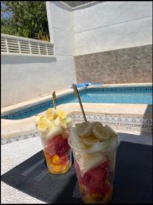 two plastic cups filled with fruit and bananas on a table at Sam in San Fulgencio