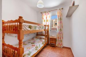 a bedroom with a bunk bed and a window at Duplex Islantilla con piscina in Islantilla +18 photos