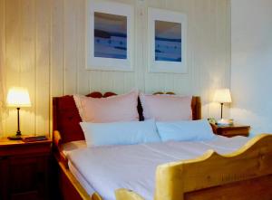 a bedroom with a bed with white sheets and two lamps at Kanne Honeymoon Apartment in Trichtingen