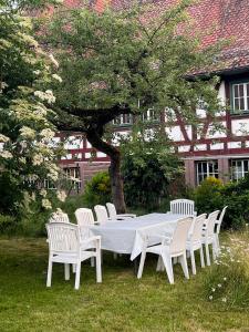 a white table and chairs sitting in the grass at Kanne Honeymoon Apartment in Trichtingen