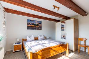 a bedroom with a wooden bed in a room at Dat Möhlenhus Peter Jensen in Pellworm