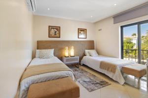 a bedroom with two beds and a balcony at Sunshine Villa em Vilamoura in Vilamoura +24 photos