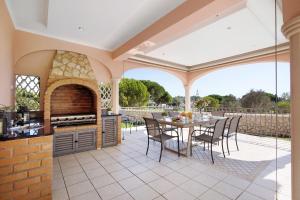 an outdoor kitchen and dining area with a table and chairs at Sunshine Villa em Vilamoura in Vilamoura