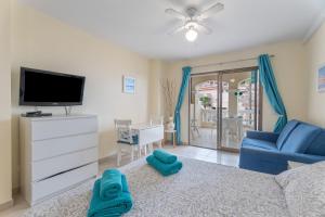 a living room with a couch and a tv at Castle Harbour in Los Cristianos