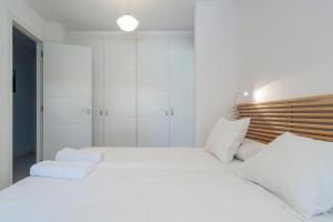 1 dormitorio blanco con 1 cama grande con almohadas blancas en BLUE FIN Tarifa, en Tarifa 42 fotos más