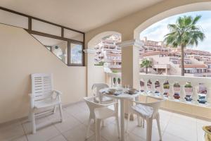 a dining room with a table and chairs and a balcony at Castle Harbour in Los Cristianos