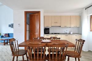 a kitchen and dining room with a wooden table and chairs at Villa Elena in Castelsardo