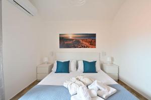 a bedroom with a white bed with blue pillows at Villa Elena in Castelsardo +19 photos