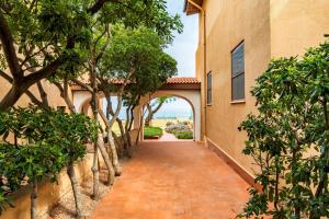 a brick walkway leading into a building with trees at Villa Elena in Castelsardo