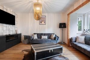a living room with a couch and a tv at Haus Rübezahl in Bayerisch Gmain