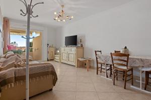 a bedroom with a bed and a table and a tv at Petit Paradis à Cavalaire in Cavalaire-sur-Mer