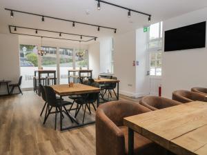 a restaurant with tables and chairs and a flat screen tv at Beech Timber Lodge in Keswick