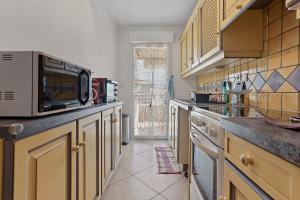 a kitchen with a microwave and a counter top at Petit Paradis à Cavalaire in Cavalaire-sur-Mer